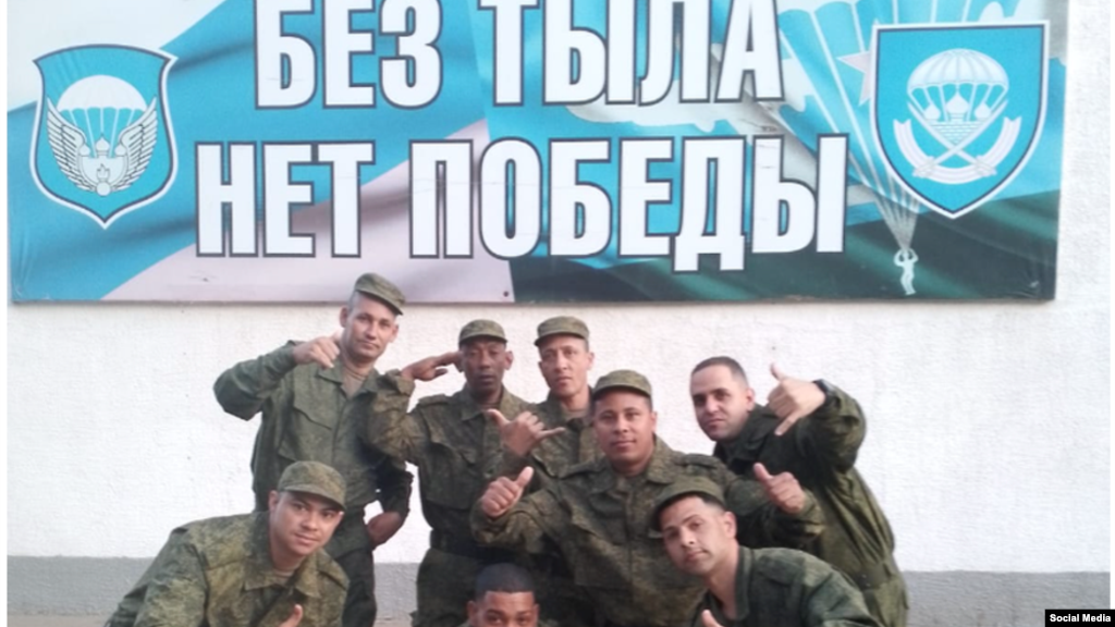 Cubanos en el Regimiento 137 de los paracaidistas rusos. El cartel, escrito en idioma ruso y que indica "Sin retarguardia no hay victoria", incluye el emblema del 137 Regimiento de Paracaidistas (der.) y a la izq. de la 106 División Aerotransportada de las Tropas de Paracaidistas. (Cortesía Alain Paparazzi cubano).