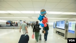 Foto de archivo. Una familia en el Aeropuerto Internacional de Miami. Foto: Alexia Fodere para Voz de América.