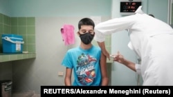 Cristian Artimbau, de 14 años, recibe una dosis de la vacuna Soberana 02 durante sus ensayos clínicos en un hospital en medio de preocupaciones sobre la propagación de la enfermedad del coronavirus.
