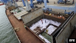 Trabajadores desvelan los contenedores ocultos entre sacos de azúcar que presumiblemente contienen material bélico, dentro del barco norcoreano Chong Chon Gang hoy, martes 16 de julio de 2013, en el muelle de Manzanillo en Colón (Panamá). Las autoridades