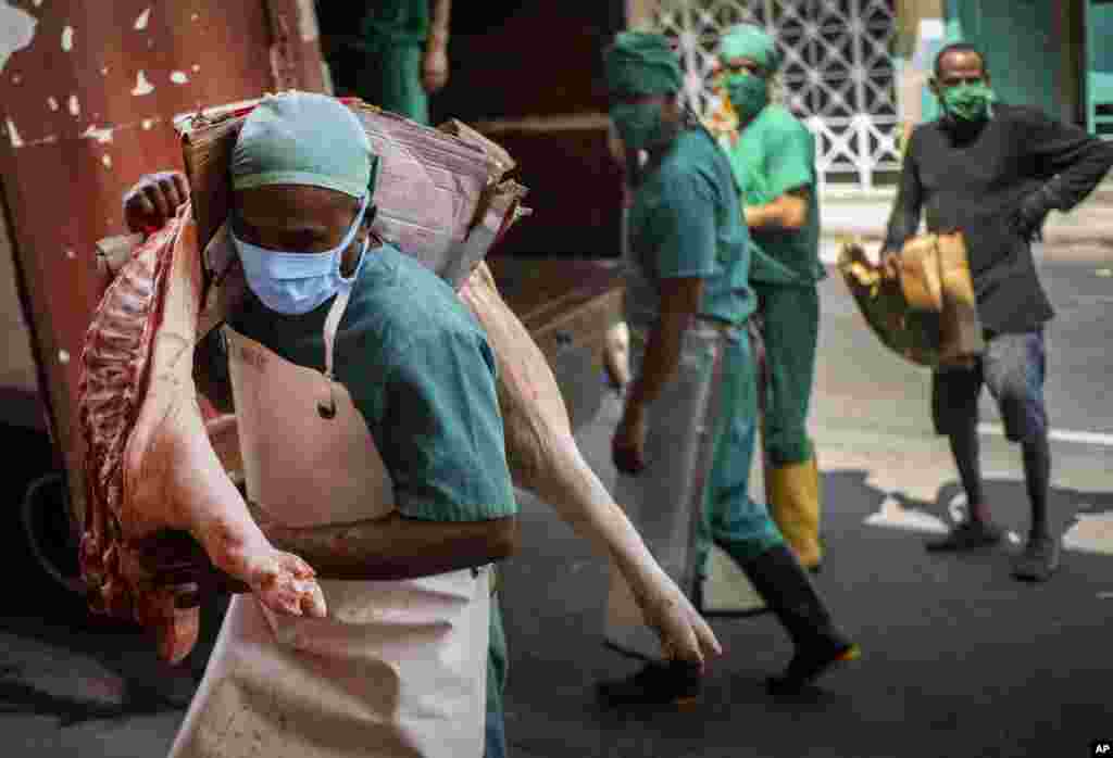 Trabajadores se protegen con máscaras del contagio del coronavirus. AP Photo/Ramon Espinosa