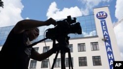 Un camarógrafo en Kyiv, Ucrania, el 13 de julio de 2019, tras un ataque a la estación 112 TV Channel. (AP Photo/Evgeniy Maloletka).