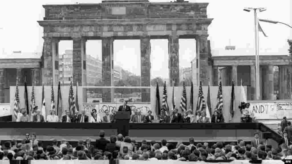 Fotografía de archivo del 12 de junio de 1987 que muestra al por entonces presidente de Estados Unidos Ronald Reagan (c) y al canciller alemán Helmut Kohl (a la derecha de Reagan) durante una ceremonia en el lado oeste del Muro de Berlín (Alemania), frente a la Puerta de Brandemburgo. Los berlineses gritaban: "Sr. Gorbachov, ídestruya este muro!". Reagan viajó a Berlín para celebrar el 750º aniversario de la ciudad. La construcción de la barrera comenzó el 13 de agosto de 1961 y el muro cayó el 9 de noviembre de 1989.