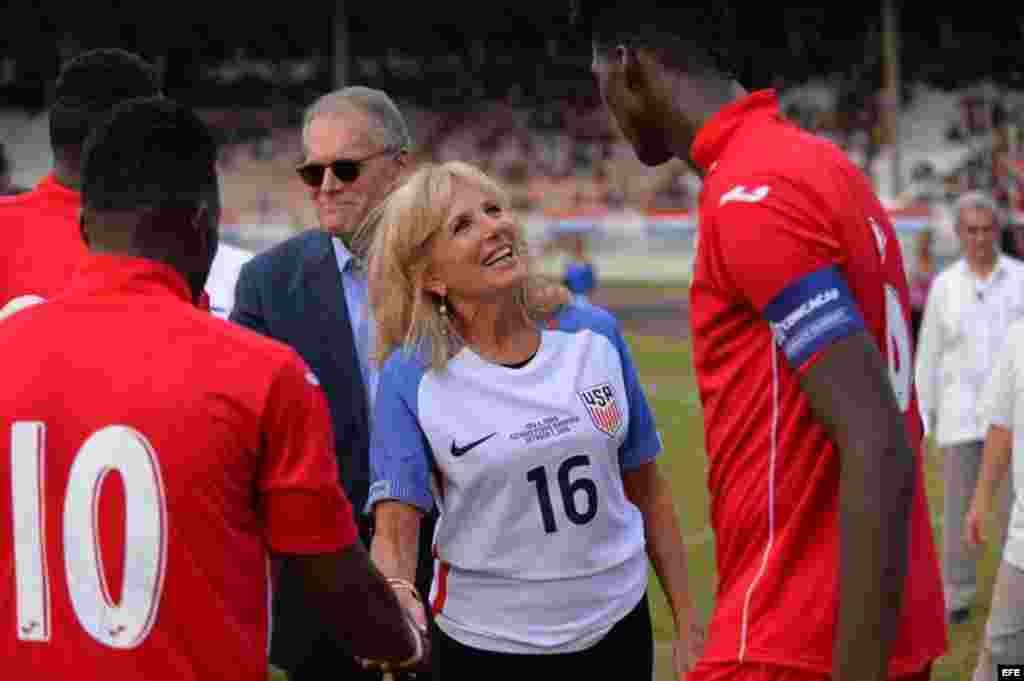 La esposa del vicepresidente de EEUU, Joe Biden, Jill Biden, y el Embajador de EEUU en Cuba, Jeffrey De Laurentis, saludan a los futbolistas cubanos en el estadio Pedro Marrero de La Habana.  