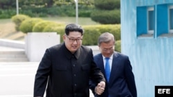 El dictador norcoreano, Kim Jong-un (d), y el presidente surcoreano, Moon Jae-in (i), se dan la mano mientras caminan por la Zona Desmilitarizada en Panmunjom (Corea del Sur), 27 de abril de 2018.