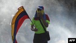 Un opositor sostiene una bandera venezolana durante las manifestaciones en Caracas contra Nicolás Maduro.