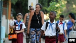 Tres niños posan con una bandera cubana durante el primer día del curso escolar 2015-2016 hoy, martes 1 de septiembre de 2015, en La Habana (Cuba). Cuba comienza hoy el curso escolar 2015-2016 con cerca de dos millones de estudiantes en más de 10.300 esc