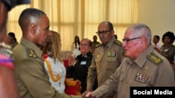 El ministro de las FAR, General de Cuerpo de Ejército Álvaro López Miera, saluda a un oficial de las Fuerzas Armadas con grados de primer coronel.