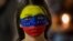 Una mujer con el rostro pintado con los colores de la bandera venezolana participa en una protesta en Caracas.