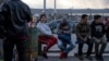 Migrantes esperan a la entrada del Puente Internacional Paso del Norte, en Ciudad Juárez.