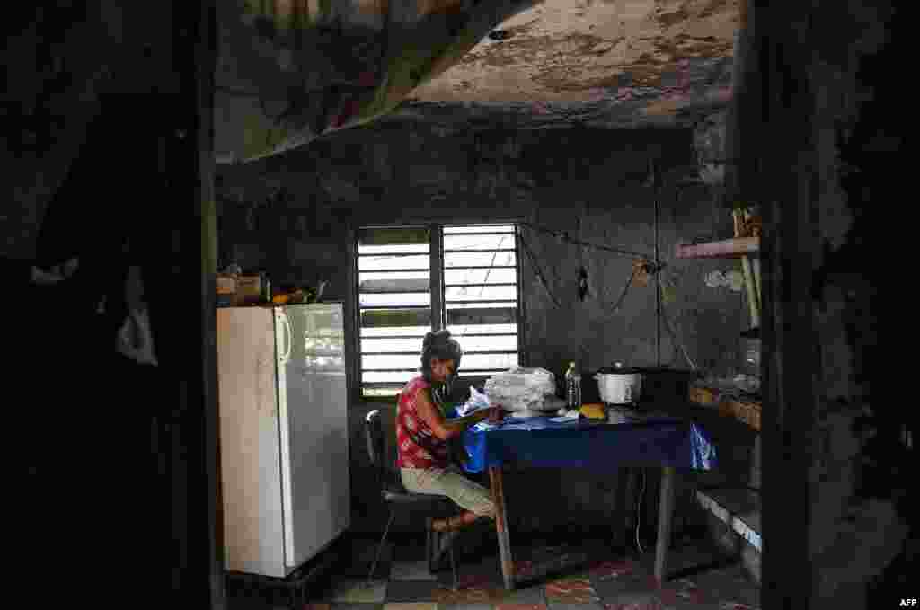 Una señora escoge arroz en su casa en El Caney, Santiago de Cuba el 21 de junio de 2017. Más de un 50% de los cubanos vive por debajo del umbral de pobreza.  AFP PHOTO/YAMIL LAGE
