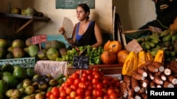 Una mujer vende vegetales y frutas en un mercado local en La Habana.