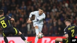 El portugués Cristiano Ronaldo intenta marcar ante el escocés Anthony Ralston, a la derecha, durante el partido de fútbol de la UEFA Nations League entre Escocia y Portugal en el Hampden Park de Glasgow, Escocia. 15/10/2024 (AP Foto/Scott Heppell)