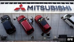 Varios coches Mitsubishi se reflejan en el techo acristalado de la sede de Mitsubishi Motors Corp.'s en Tokio.