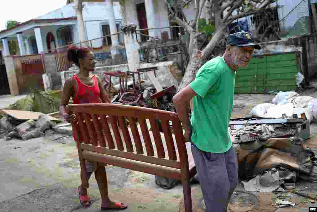 Una pareja saca sus muebles para secarlos al sol tras el paso del huracán Irma en La Habana.