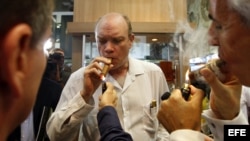 El ministro cubano de Inversión Extranjera, Rodrigo Malmierca (c), enciende un puro durante la inauguración del XIV Festival del Habano, en La Habana