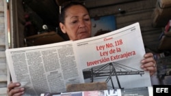 Una vendedora de periódicos lee un tabloide especial confeccionado por el diario Granma donde se divulga la nueva Ley de Inversión Extranjera.