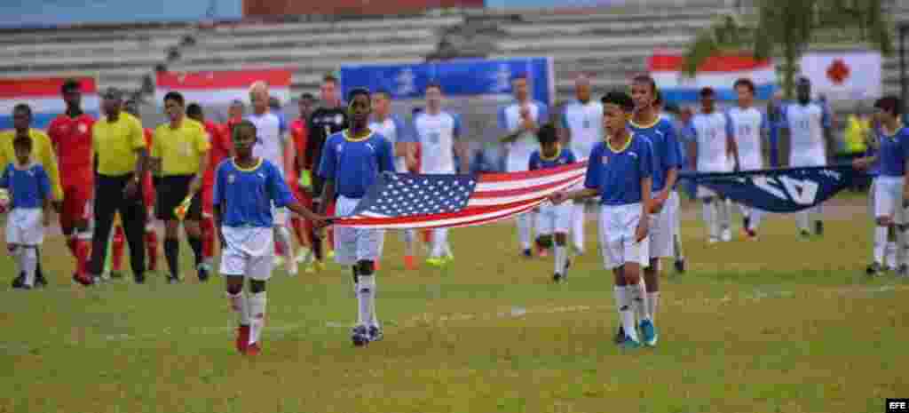 Niños deportistas portan la bandera de EE.UU., en el Estadio Pedro Marrero en La Habana, el 7 de octubre de 2016, durante la inauguración del partido amistoso de fútbol entre Cuba y Estados Unidos.  