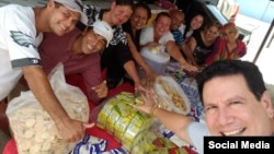 El Apóstol Bernardo de Quesada Salomón, junto a feligreses del ministerio Fuego Y Dinámica, preparan paquetes de alimentos para ayudar a necesitados.