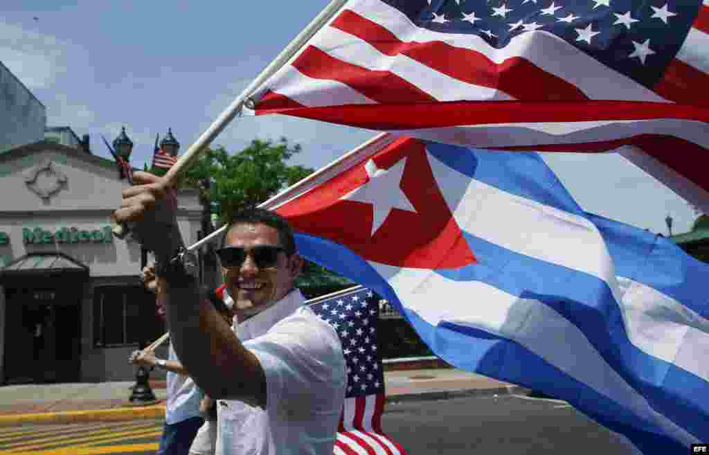Residentes de New Jersey participan con banderas de EEUU y Cuba en el desfile anual cubano.