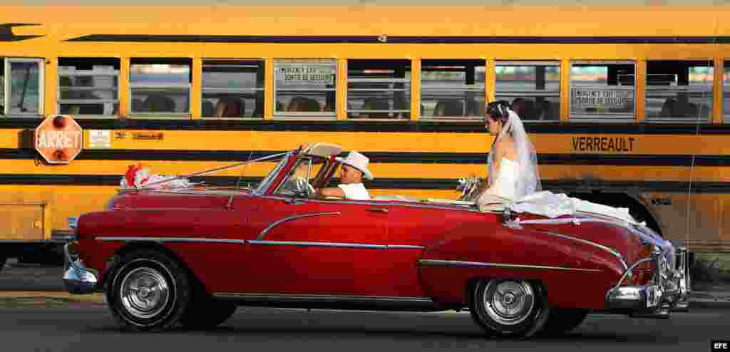 Una pareja de recién casados viaja en un viejo auto descapotable en La Habana (Cuba).