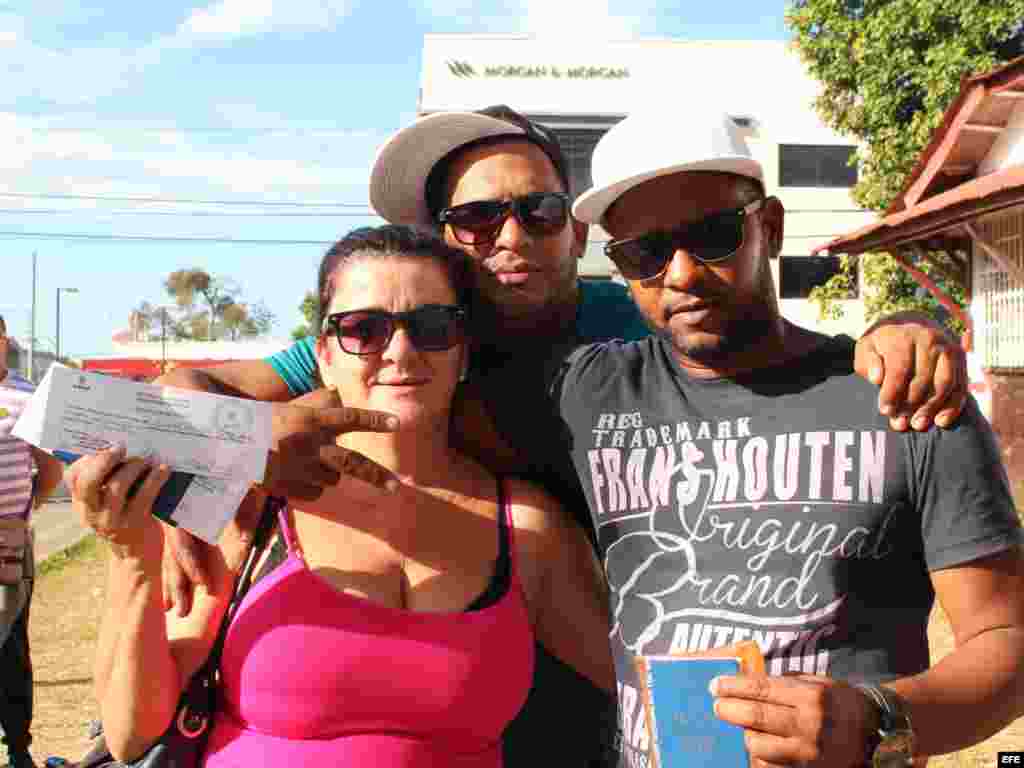 La cubana Isabel Pérez muestra el certificado de salud y los pasaportes de sus familiares que le permiten comprar el boleto de avión, por 523.50 dólares cada uno.