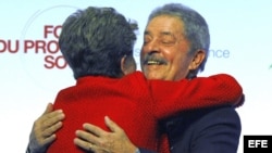 La presidente brasileña Dilma Rousseff (i) abraza a su predecesor en el cargo Lula Da Silva (d) durante su visita al Foro Social de París, Francia.