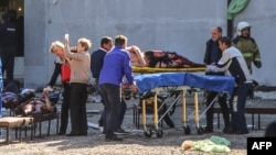 Rescatistas cargan a los heridos en el ataque al Instituto Politécnico de Kerch, en Crimea.