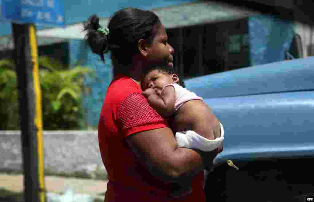 Una mujer carga a su pequeño hijo en La Habana (Cuba)14 de agosto de 2014. La sociedad “tiene un ideal reproductivo que retarda la procreación, asociado a factores de índole económico, social y de superación personal, entre otros”.
