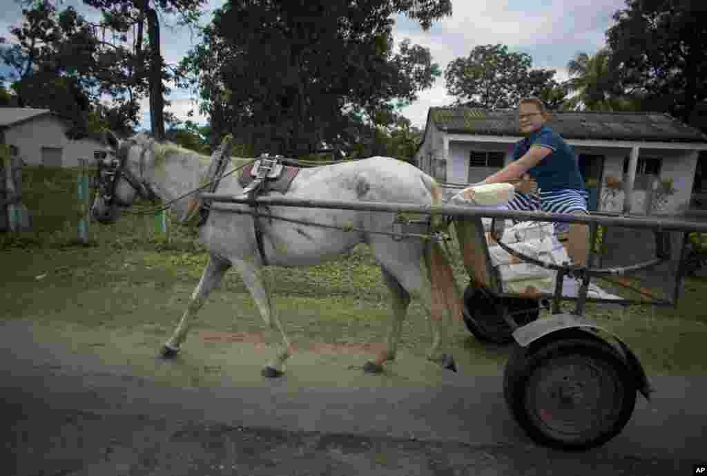 Un niño lleva material escolar en un carro tirado por caballos en Pinar del Río. La actual crisis energética de la nación isleña ha obligado a las autoridades a dar prioridad a los vehículos de tracción animal. (AP Foto / Ismael Francisco)