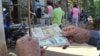 Un hombre muestra un peso convertible cubano y un dólar estadounidense frente a una oficina de la Western Union en La Habana. (Archivo)