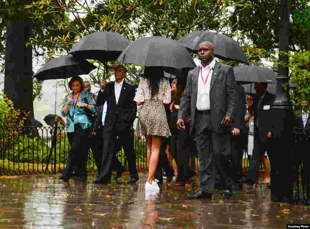 Obama y su familia recorriendo La Habana Vieja bajo la lluvia.