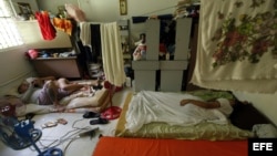 Cubanos descansan en un refugio de la institución Cáritas hoy, viernes 13 de enero de 2017, en Ciudad de Panamá (Panamá). Los más de 70 cubanos que se encuentran hospedados en un albergue de Cáritas de la capital panameña pidieron hoy a Estados Unidos que haga una excepción con todos aquellos que salieron de la isla antes de la derogación de la política "pies mojados/pies secos" y que se encuentran en Centroamérica en su tránsito hacia el país norteamericano.
