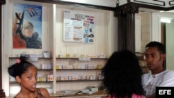 Tres jovenes conversan en una farmacia en La Habana,Cuba.