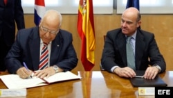 El ministro español de Economía y Competitividad en funciones, Luis de Guindos (d), y el vicepresidente del Consejo de Ministros de Cuba, Ricardo Cabrisas Ruiz (i), durante la firma de los acuerdos para reestructurar la deuda cubana con España. (Archivo)