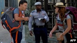 Un policía guía a turistas en una calle de La Habana en medio de la pandemia de coronavirus.