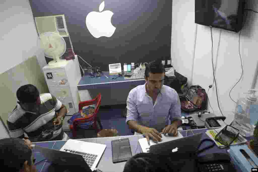 Un joven cubano atiende en su negocio de reparaciones de Iphones, en La Habana.