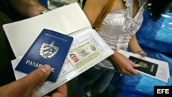 hombre muestra su pasaporte en el aeropuerto Internacional de Miami (EEUU) antes de viajar a Cuba.