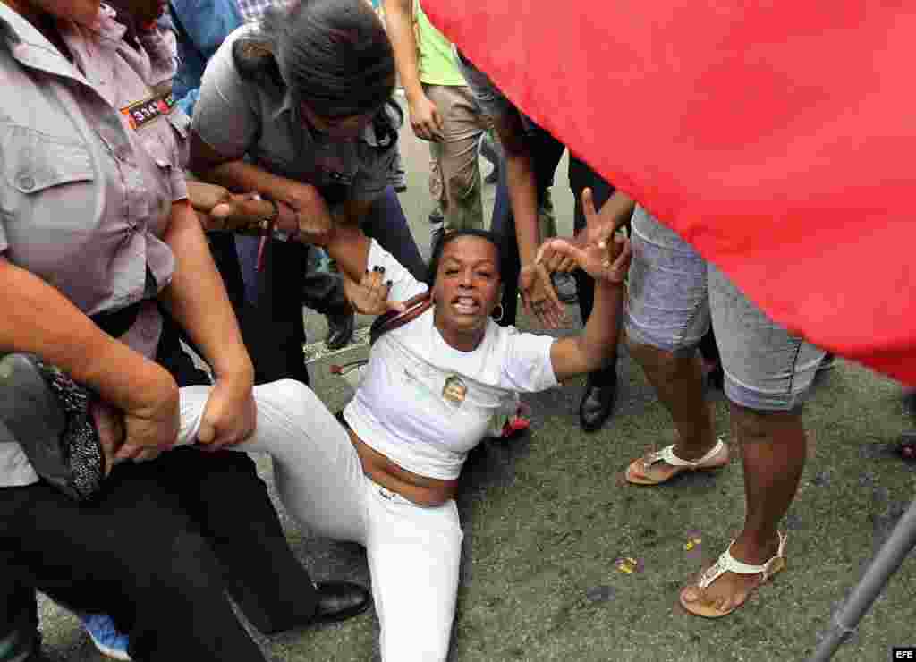 Yaquelin Boni, de las Damas de Blanco es detenida, entre hostigamiento e insultos de sectores oficialistas el 10 de diciembre de 2015, en La Habana (Cuba).