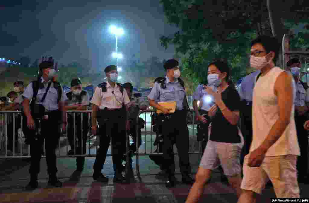 Agentes de policía vigilan los alrededores del Victoria Park, en Hong Kong, durante una vigilia para conmemorar el 32 aniversario de la represión militar contra el movimiento estudiantil en la plaza Tiananmen de Beijing.