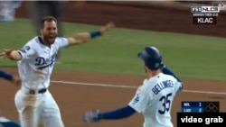 El jardinero central Chris Taylor (izq.) corre a felicitar a Cody Bellinger por su hit en la parte baja de la 13ra entrada, que dio la victoria a los Dodgers 2-1 frente a los Cerveceros.