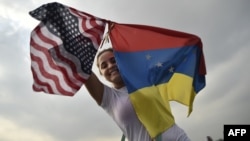 Una mujer sostiene las banderas de Venezuela y EEUU en el concierto de apoyo a la ayuda humanitaria en Cúcuta, en febrero pasado.