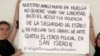 Las artistas cubanas y miembros del grupo 27N, Katherine Bisquet y Camila Lobón, alzan un cartel en apoyo a Luis Manuel Otero Alcántara.